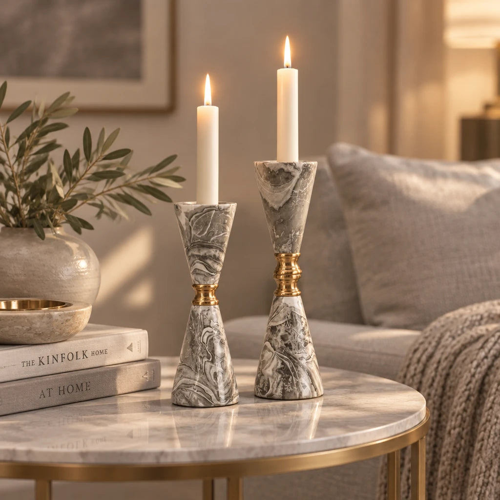 A pair of elegant tapered candlesticks with gray and white marbled stone-like bodies and polished gold-tone neck accents, displayed on a light gray studio background.