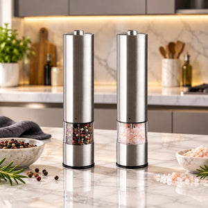 Two stainless steel electric pepper and salt mills standing side by side on a white background, one filled with mixed peppercorns and the other with pink salt.