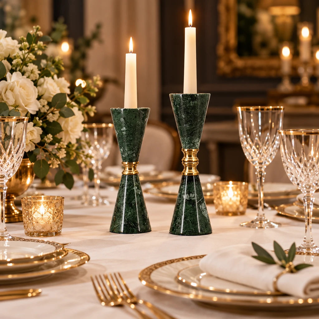 A pair of green marble candlesticks with polished gold metal accents, standing upright against a light gray background.
