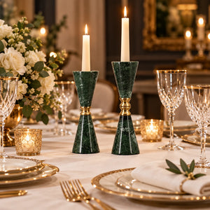 A pair of green marble candlesticks with polished gold metal accents, standing upright against a light gray background.
