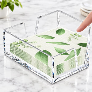 A clear acrylic note holder tray holding a stack of white paper napkins with a green leaf pattern, with a finger touching the right side of the holder. Text at the bottom right reads 'Easy fit in your.