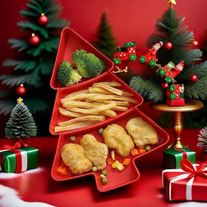 A red Christmas tree-shaped serving tray filled with broccoli, fries, and chicken nuggets, styled on a red table with miniature Christmas trees, ornaments, gift boxes, and a small train decoration.